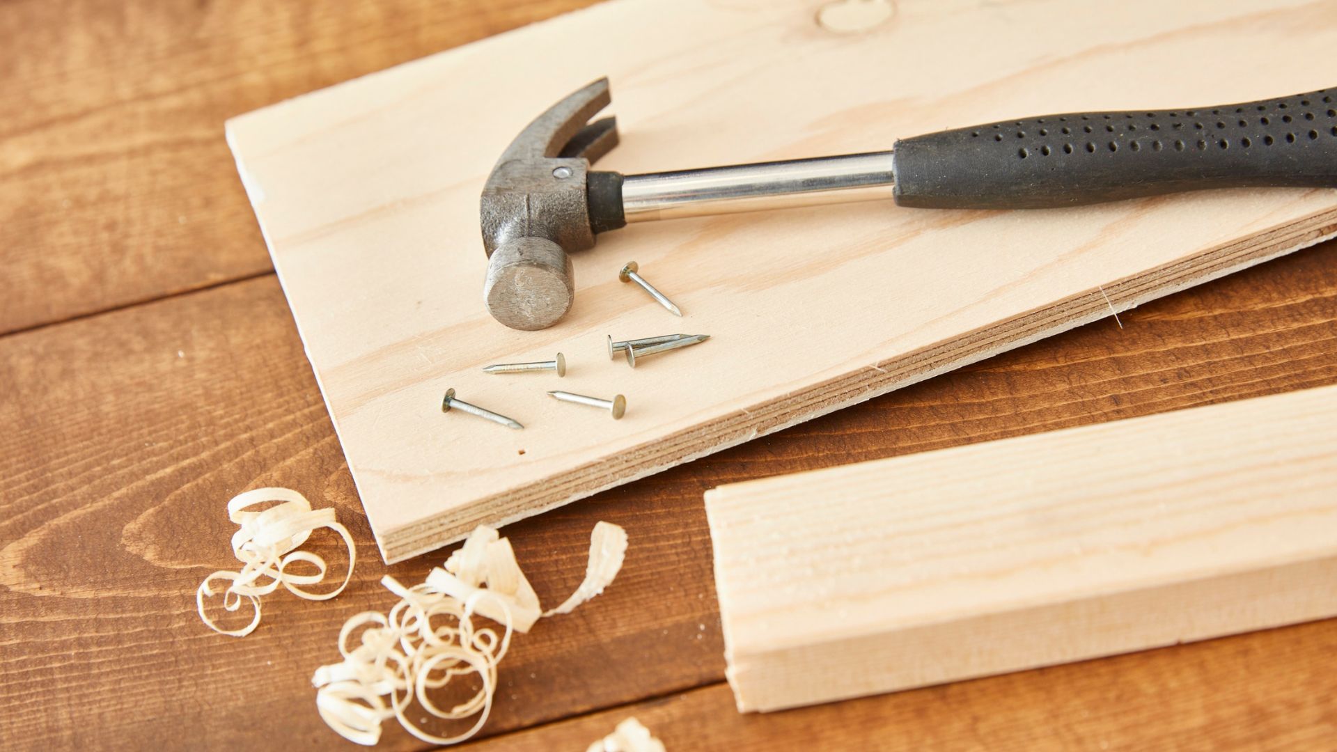 silver hammer lying on a wooden board